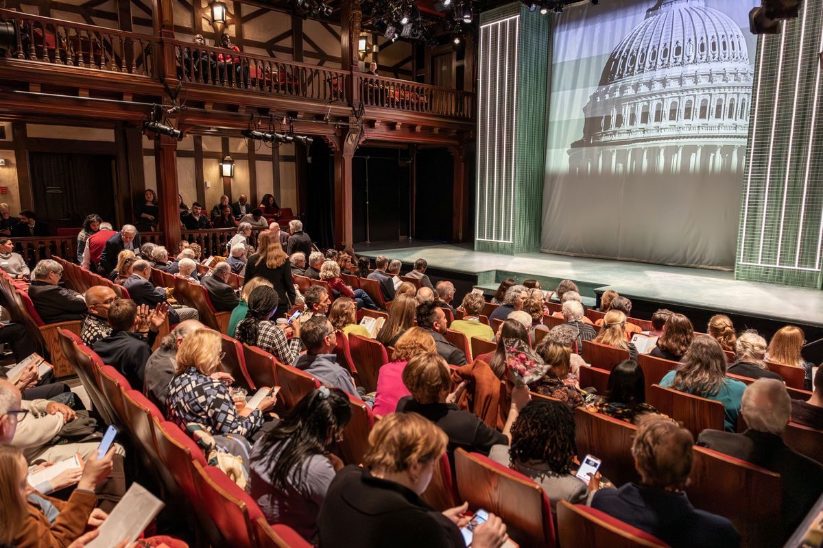 Audience members waiting for a play to begin