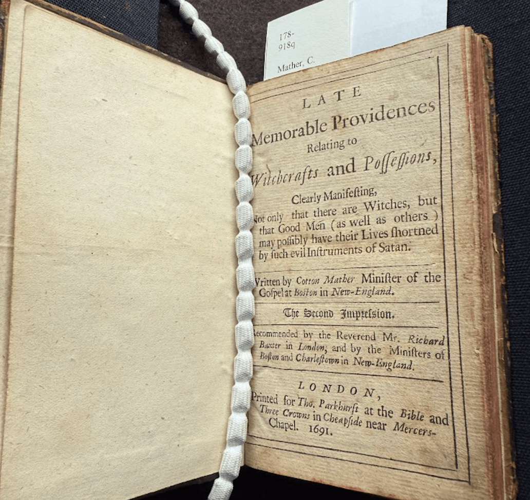 An opening of a printed book. On the left is a blank page and on the right is a printed title page.