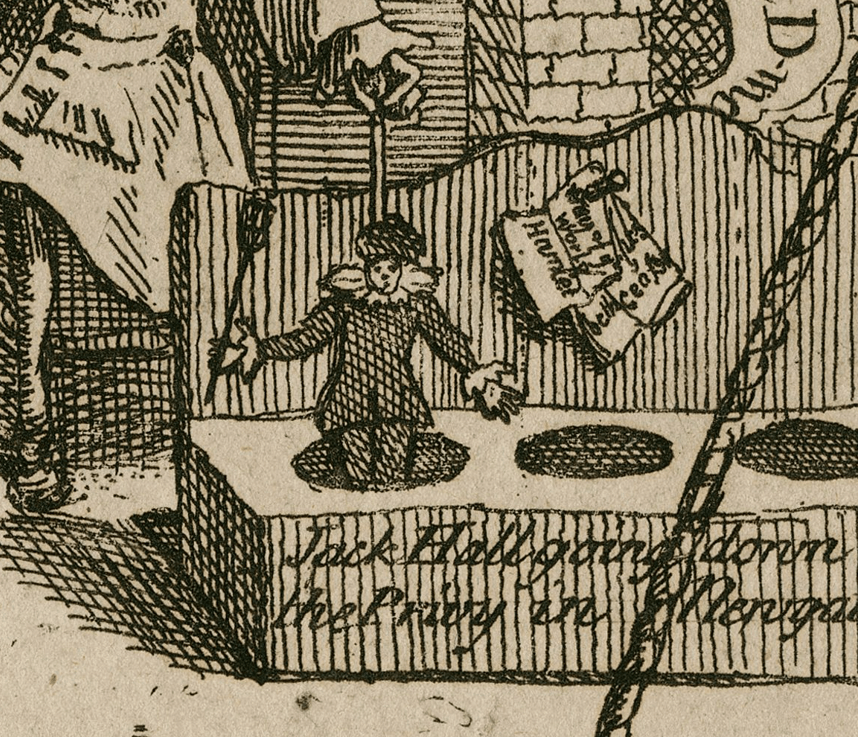 A puppet pops out of a crude toilet. Beside it, nailed to the wall to be used as toilet paper is Hamlet