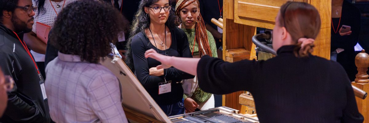 A group of people standing around a printing press.