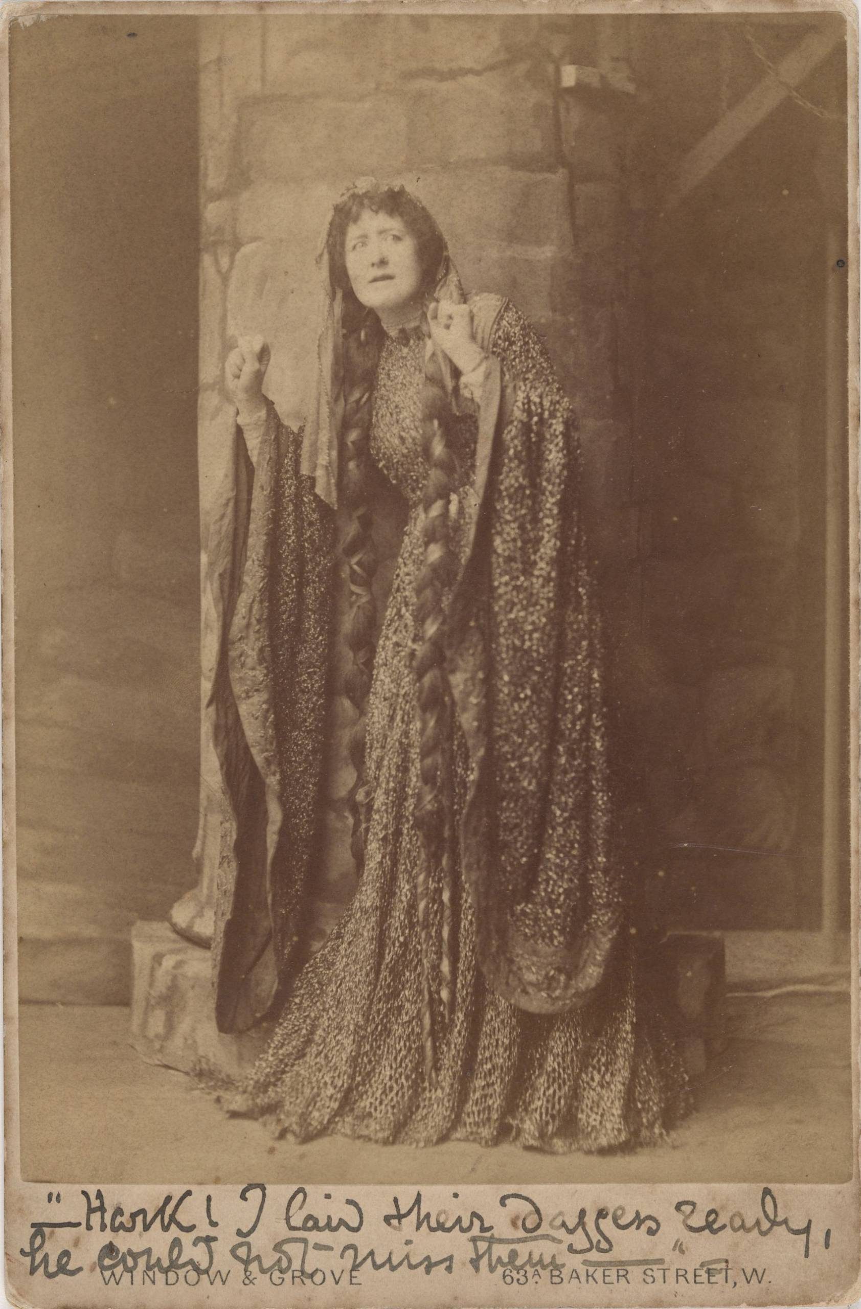 A sepia-toned photograph of a woman with long hair and flowing clothes. In flowing handwriting, it is captioned 