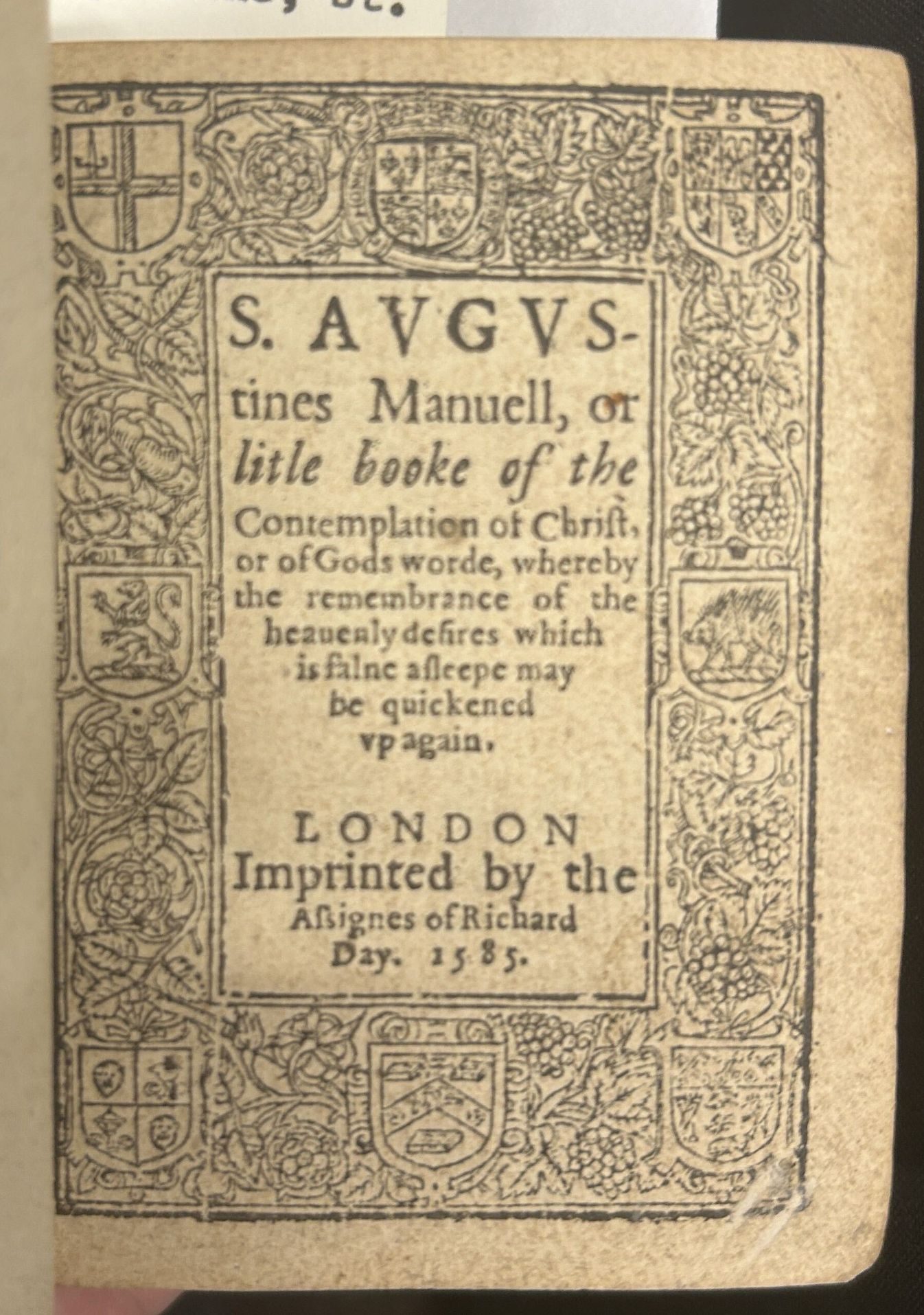 A printed title page with an elaborate border showing many crests and symbols.