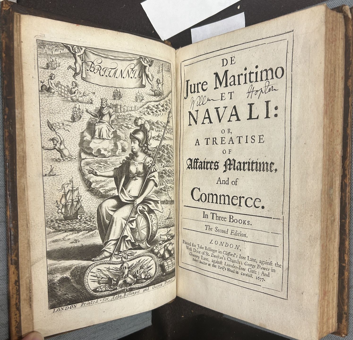 An opening of a book with an elaborate frontispiece on the left showing an allegorical woman in a helmet in a front of a map with ships in an ocean. On the right is a title page with a decorative border.