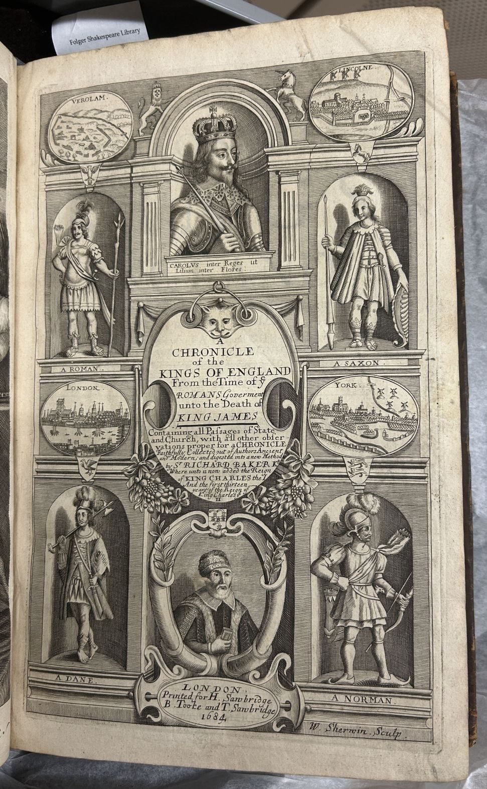 A title page with several full length portraits of historical figures and a half-length portrait of the king