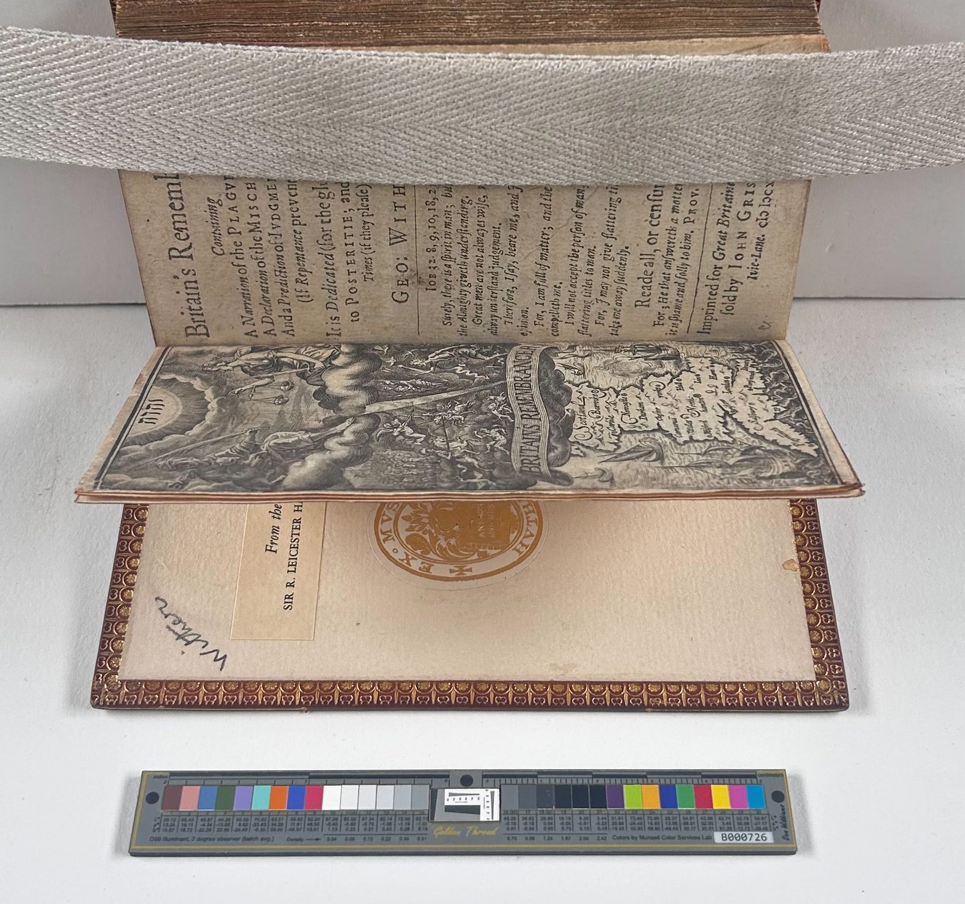 A book strapped open with the front page rising up from the board