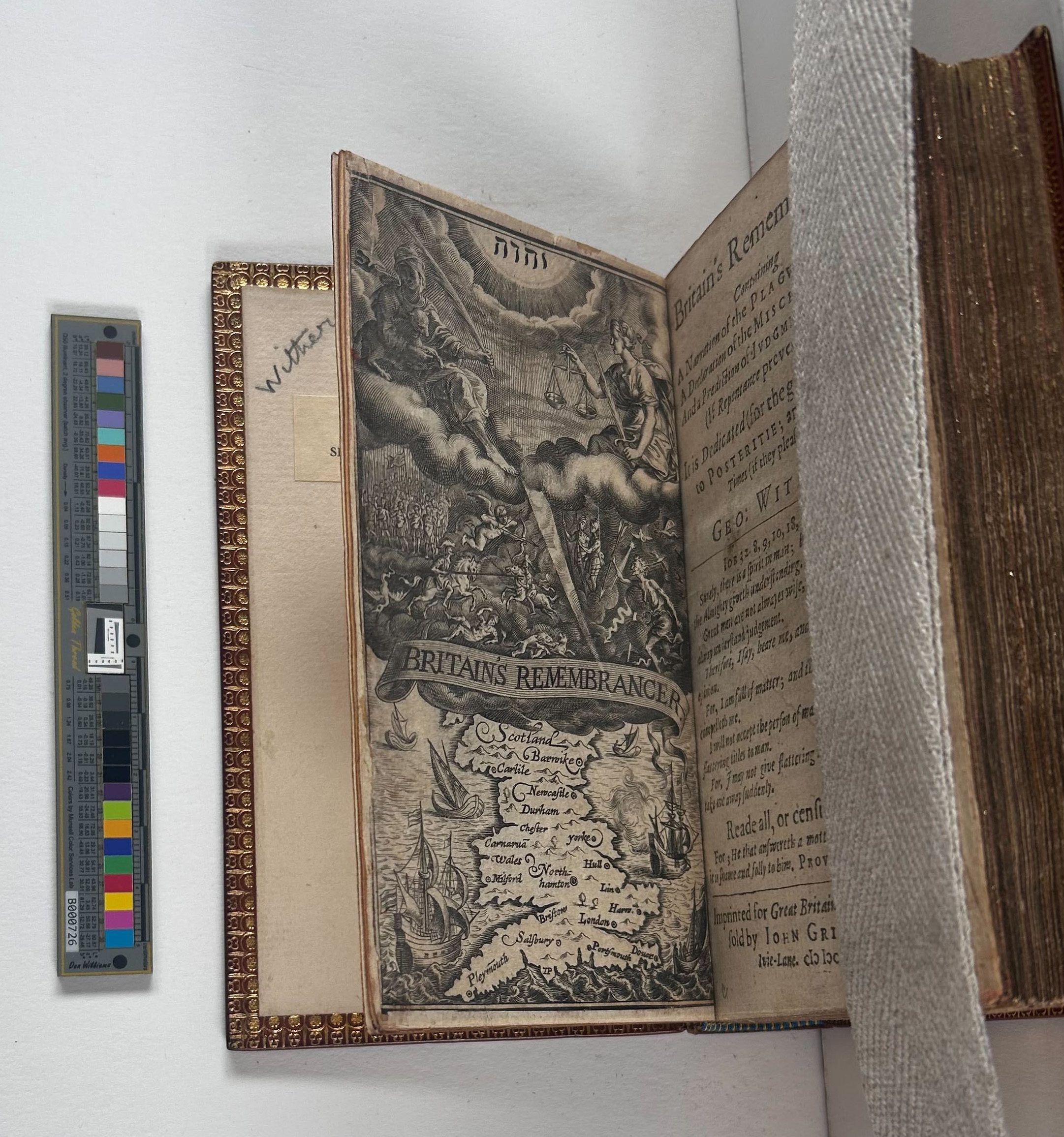 A book strapped open with the front page rising up from the board