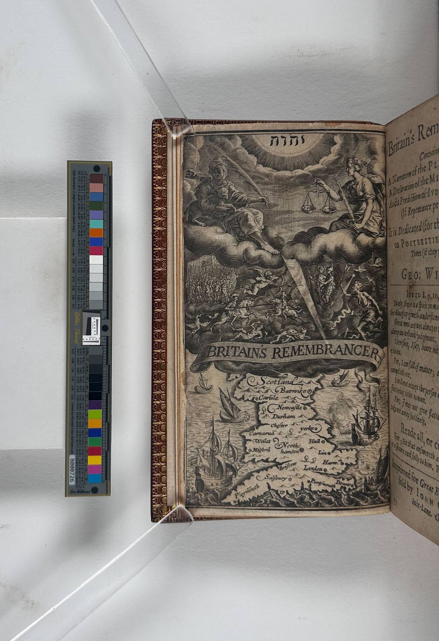 An overhead view of a book with the front page held down by two clear plastic sticks